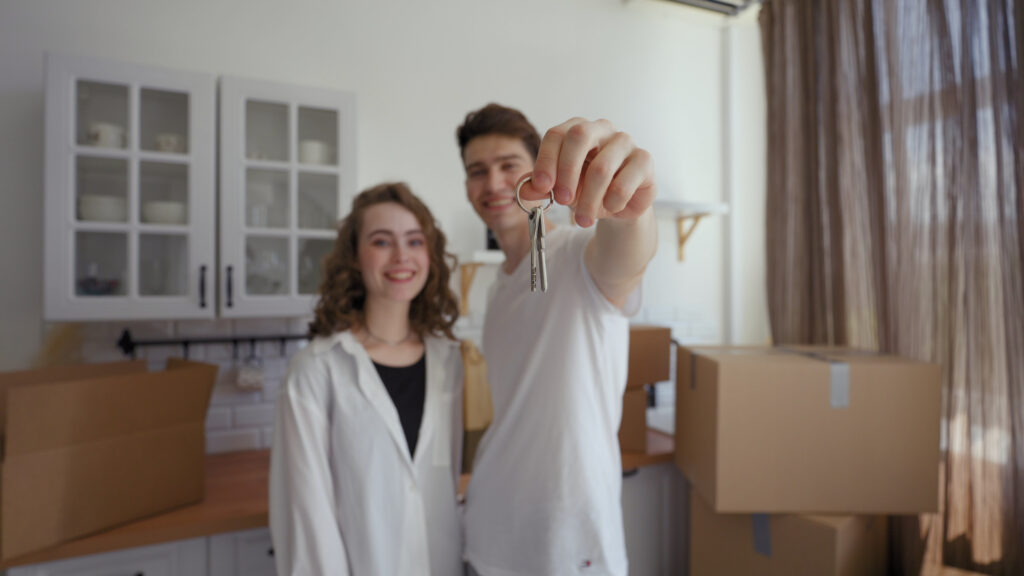 Happy couple shows keys to new apartment