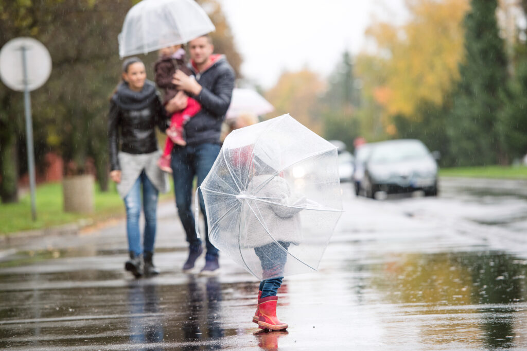family under umbrellas walking in the rain
